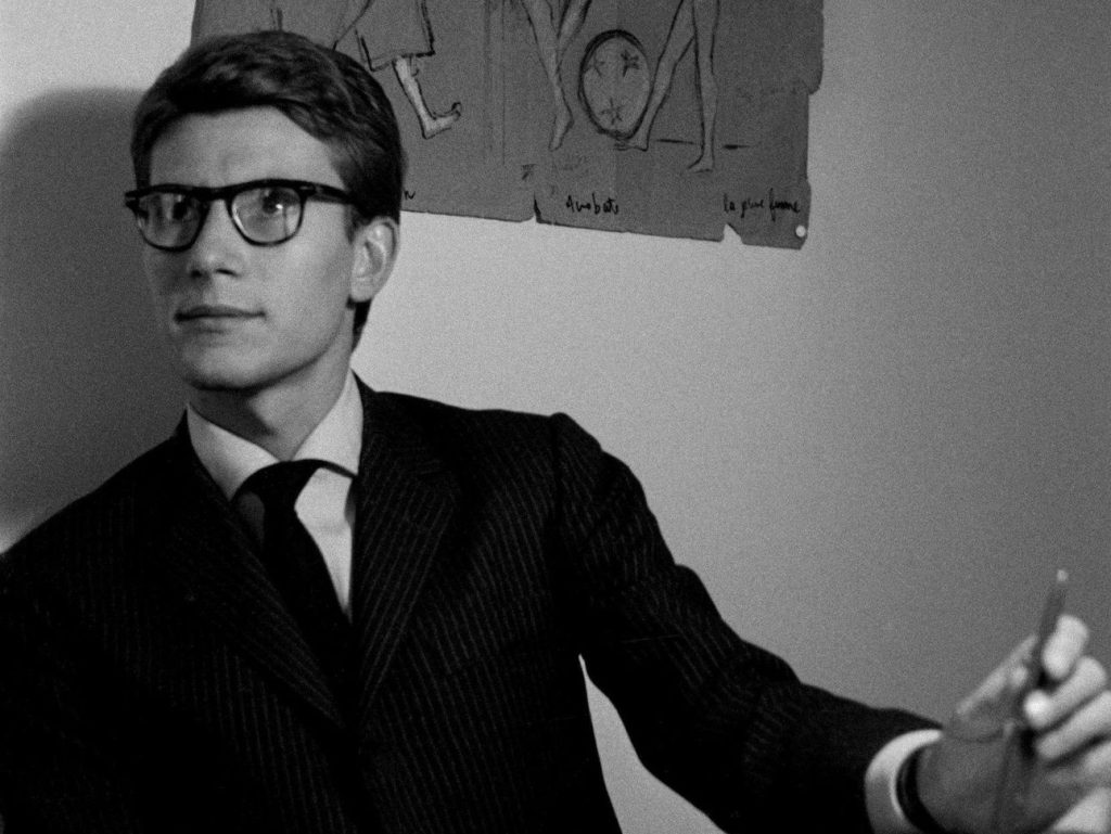 Photo d'époque de Yves saint Laurent, costume noir, cravatte et chemise blanche