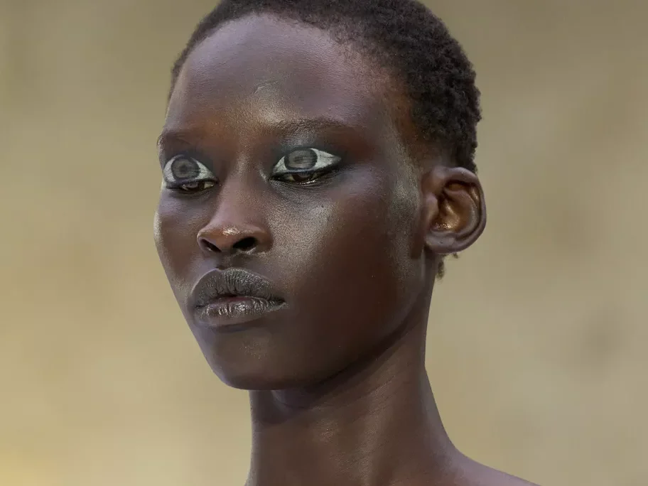 Mannequin au défilé Hodakova à Paris, maquillage graphique argenté et tenue bustier beige