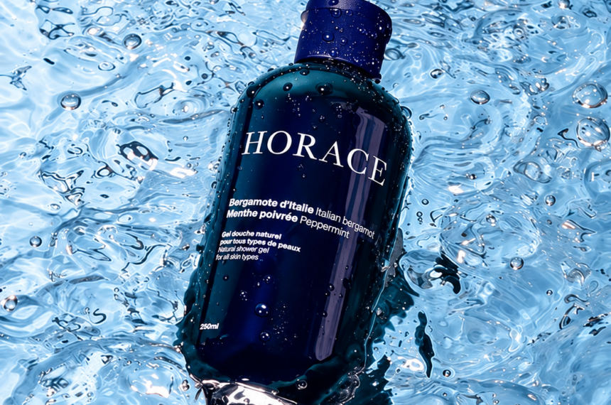 Flacon bleu du gel douche Horace à la bergamote d’Italie et à la menthe poivrée, posé dans l’eau.