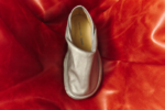 Chaussure Peu Form argentée de Camper et Issey Miyake sur un fond rouge plissé au format horizontal