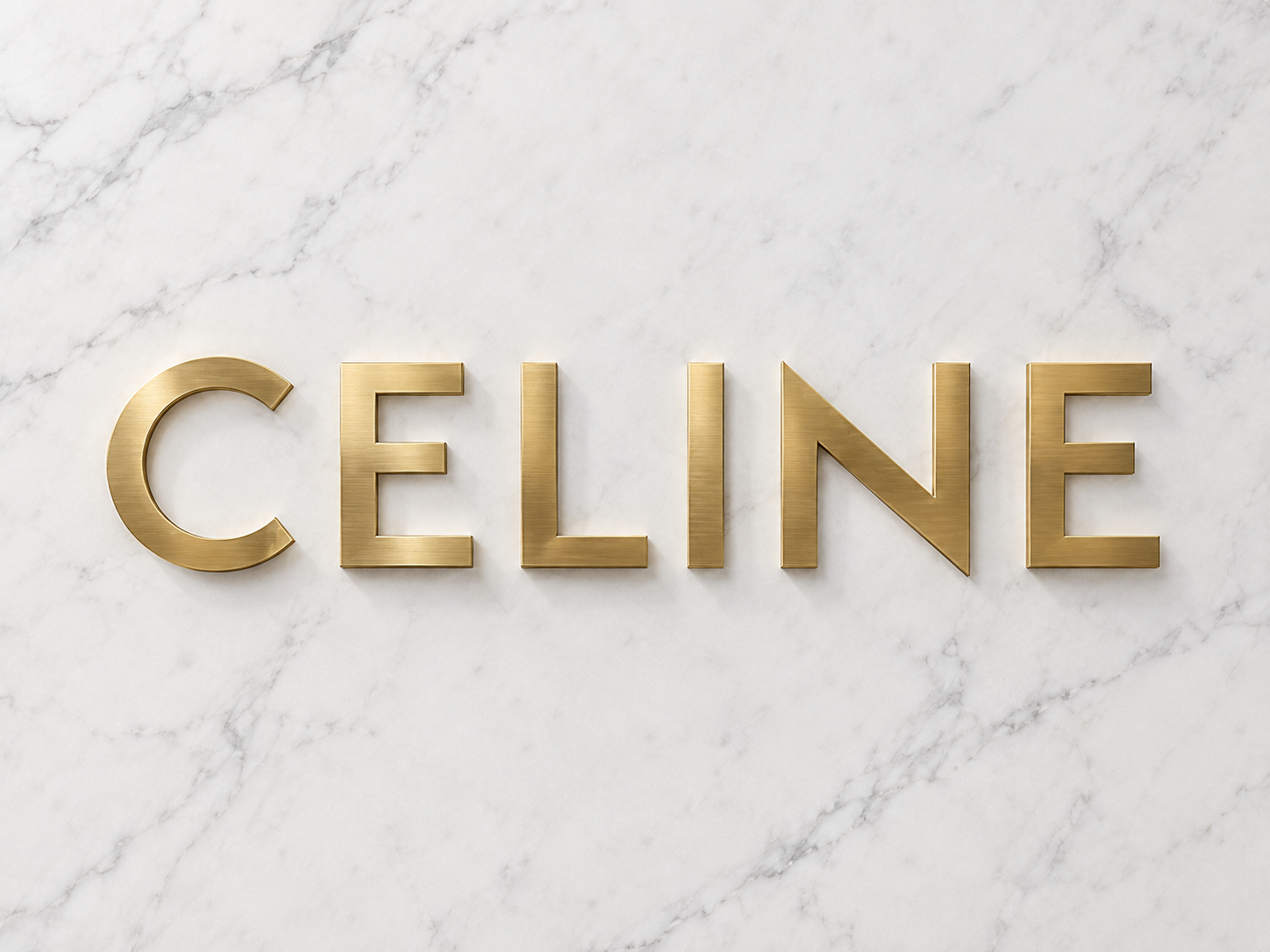 Le logo de ma marque CELINE en doré sur un fond de marbre blanc.