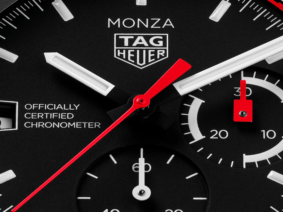 Gros plan sur le cadran noir de la TAG Heuer Monza Flyback Chronograph, avec aiguilles rouges et compteurs blancs.