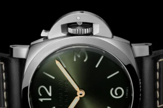 Gros plan sur le cadran vert de la Panerai Luminor Firenze 8 Giorni et son protège-couronne, sur fond noir.