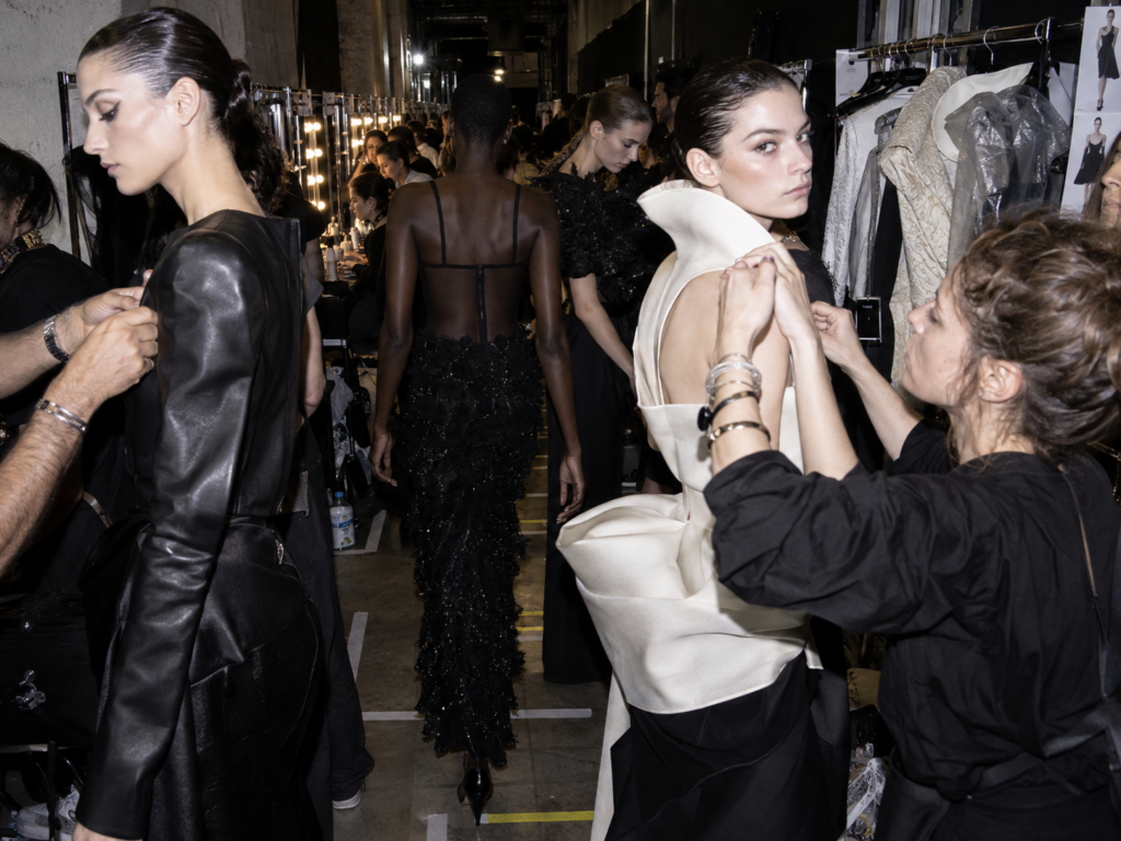 des mannequins se changent durant la Paris Fashion Week.