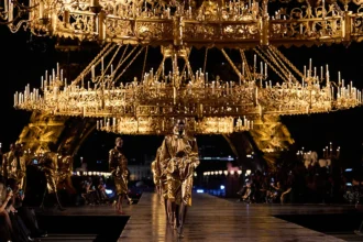 Défilé Saint Laurent printemps-été 2027 à Paris, sous des lustres dorés avec la tour Eiffel en arrière-plan.