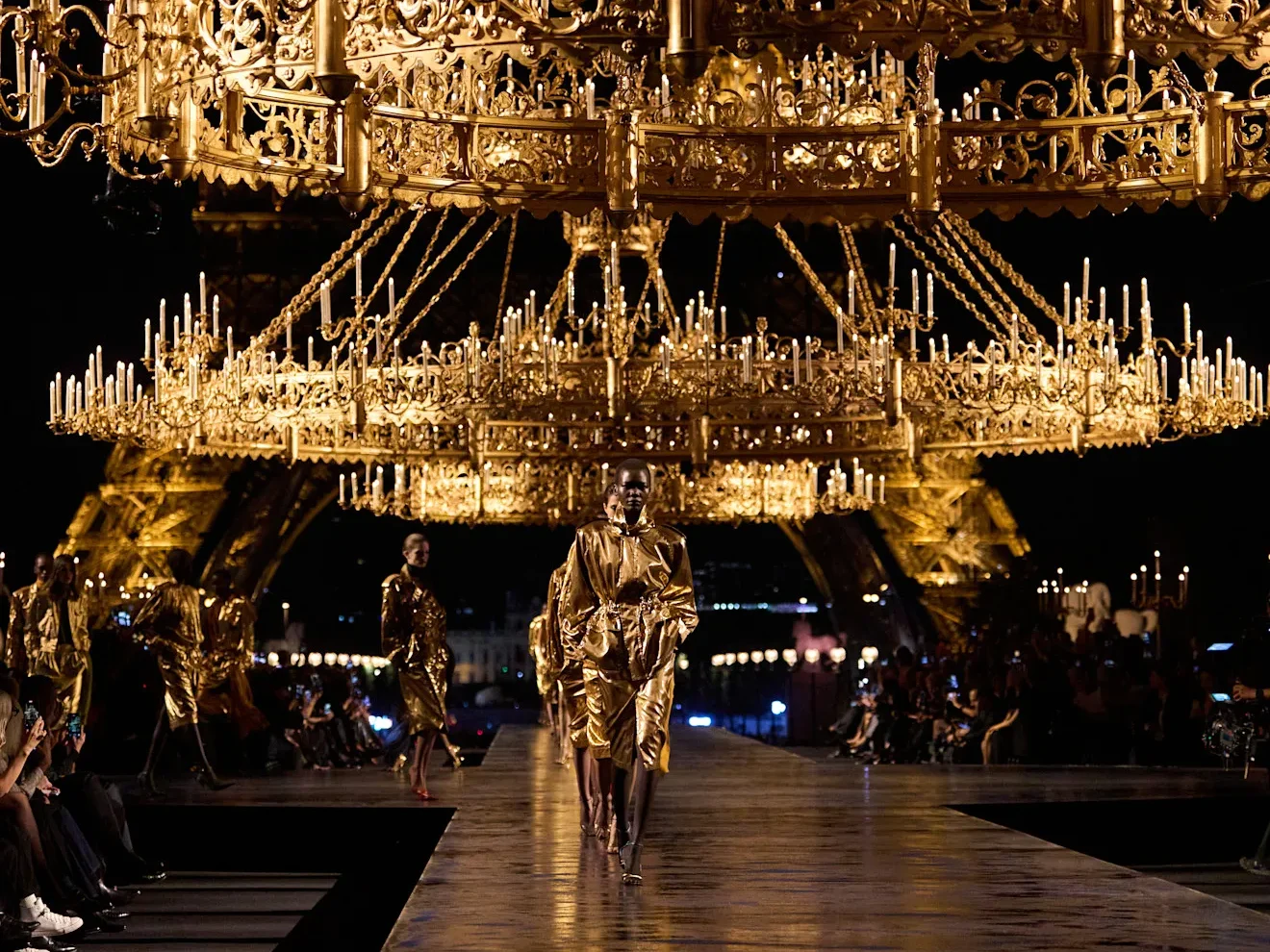 Défilé Saint Laurent printemps-été 2027 à Paris, sous des lustres dorés avec la tour Eiffel en arrière-plan.