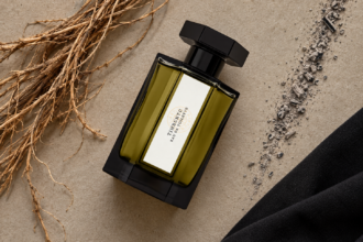 Un flacon du parfum Timbuktu de L’Artisan Parfumeur est posé devant une composition abstraite t originale.