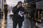 Un tour manager est au téléphone devant l'entrée d'une salle de concert avant l'ouverture des portes.