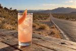 Cocktail au pamplemousse inspiré de The Joshua Tree de U2 devant une route désertique