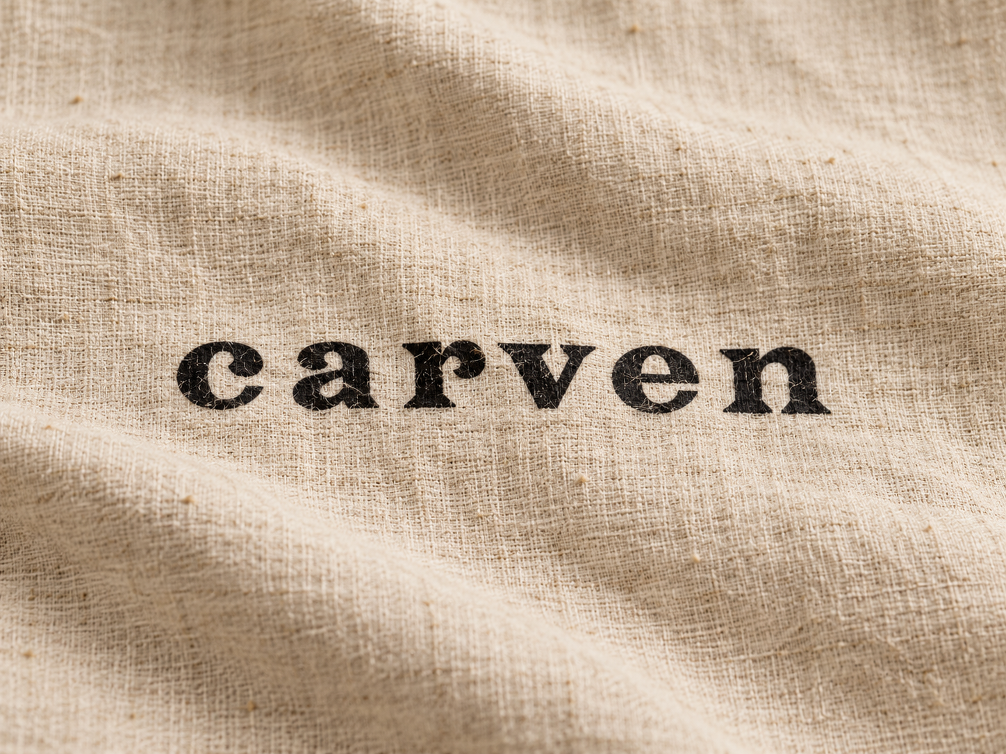 Logo Carven noir imprimé sur un tissu en lin beige