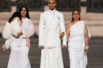 Steven Raj Bhaskaran avec sa mère, sa sœur et sa nièce à ses côtés. Vêtues de blanc au défilé Matières Fécales printemps-été 2027 à Paris