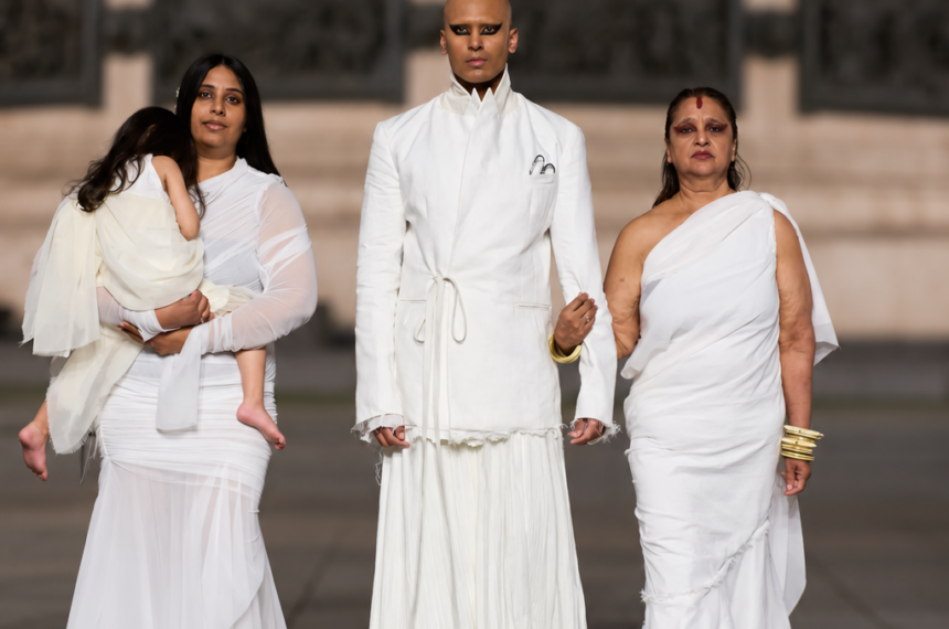 Steven Raj Bhaskaran avec sa mère, sa sœur et sa nièce à ses côtés. Vêtues de blanc au défilé Matières Fécales printemps-été 2027 à Paris