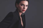 Kendall Jenner en veste noire, photographiée sur fond gris