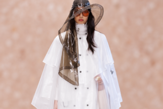 Look blanc Chloé avec cape transparente et grand chapeau au défilé printemps-été 2027 à la Paris Fashion Week.