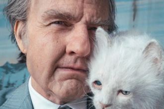 Tom Cruise dans Digger, en gros plan aux côtés d’un chat blanc aux yeux bleus.