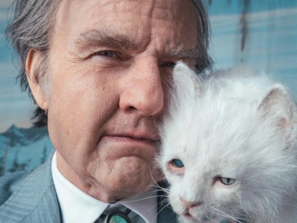Tom Cruise dans Digger, en gros plan aux côtés d’un chat blanc aux yeux bleus.