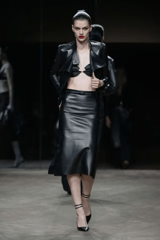 Look Tom Ford printemps-été 2027 avec veste courte et jupe en cuir noir lors de la Paris Fashion Week.