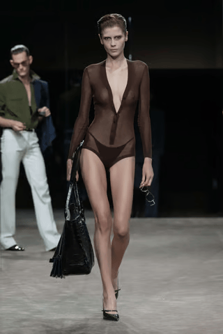 Silhouette marron Tom Ford printemps-été 2027 avec body structuré et grand sac noir sur le podium parisien.