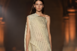 Mannequin portant une robe asymétrique plissée ivoire lors du défilé Victoria Beckham printemps-été 2027 à la Paris Fashion Week.