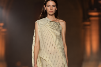 Mannequin portant une robe asymétrique plissée ivoire lors du défilé Victoria Beckham printemps-été 2027 à la Paris Fashion Week.