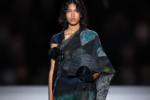 Silhouette du défilé Yohji Yamamoto printemps-été 2027 à Paris, avec une robe sombre aux motifs bleu-vert et de longues franges noires.