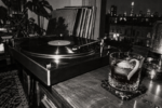 Cocktail The Darkroom dans un verre bas à côté d’une platine vinyle, dans un appartement londonien photographié en noir et blanc.