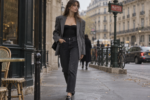 Femme portant un bustier noir, un blazer gris oversize, un jean foncé et des mocassins dans une rue parisienne.