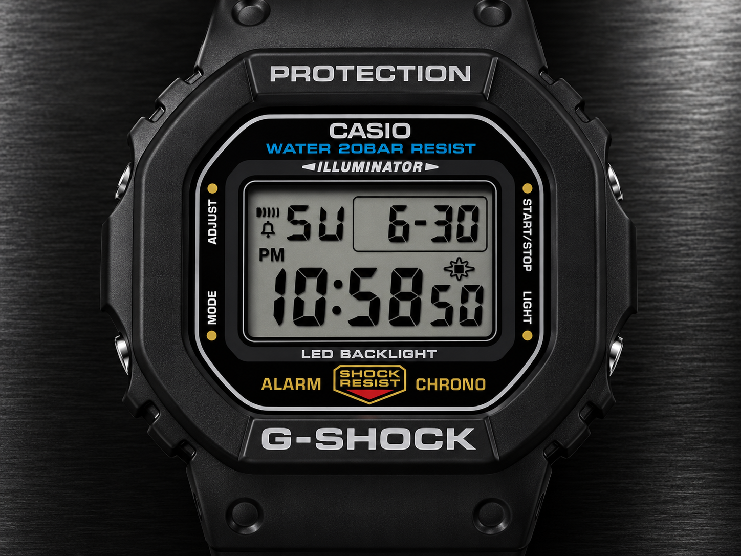 Gros plan sur le cadran numérique de la Casio G-Shock DW-5600UE-1, avec boîtier carré en résine noire sur fond de métal brossé.