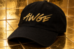 Casquette noire AWGE avec logo brodé en doré, posée sur un carrelage doré brillant.