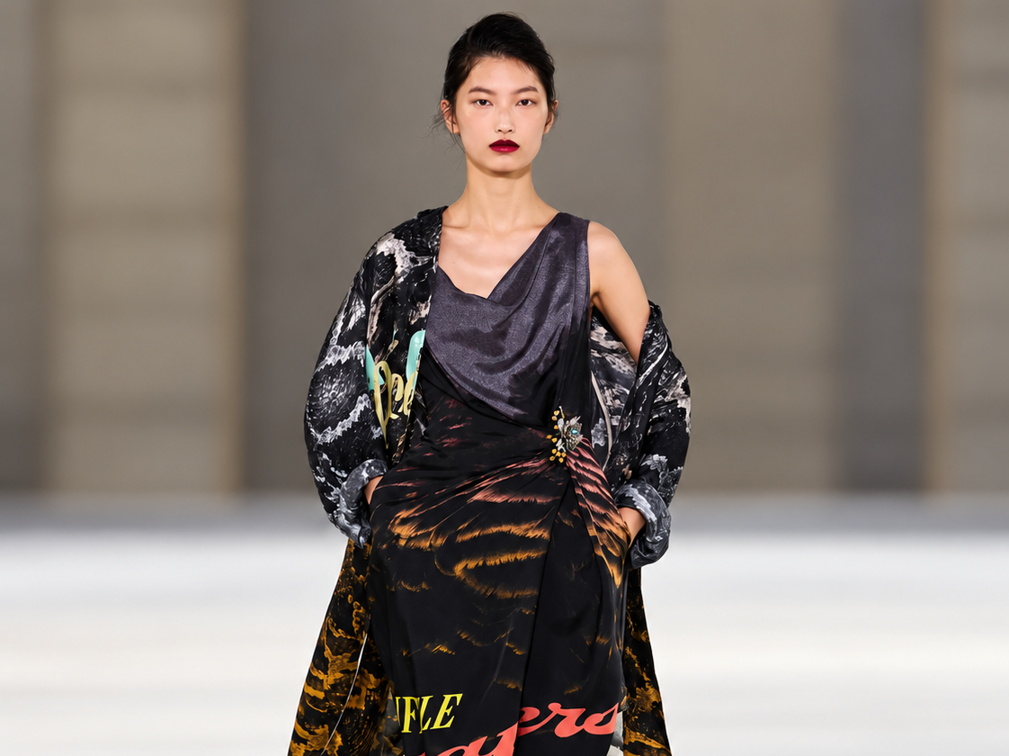 Mannequin en robe imprimée noire et manteau graphique au défilé Dries Van Noten printemps-été 2027 à Paris.