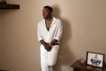 Kendrick Lamar habillé en blanc dans une pièce aux murs beiges dans le clip Swimming Pools (Drank).