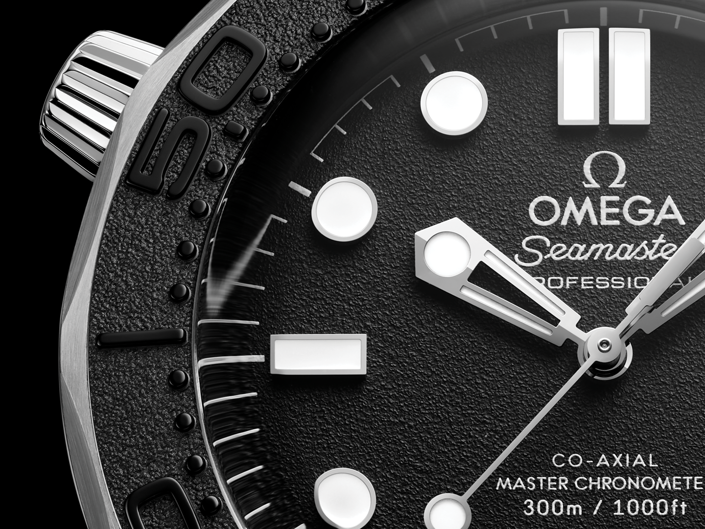 Gros plan du cadran noir texturé de l’Omega Seamaster Diver 300M Spectre, avec aiguilles et index blancs.