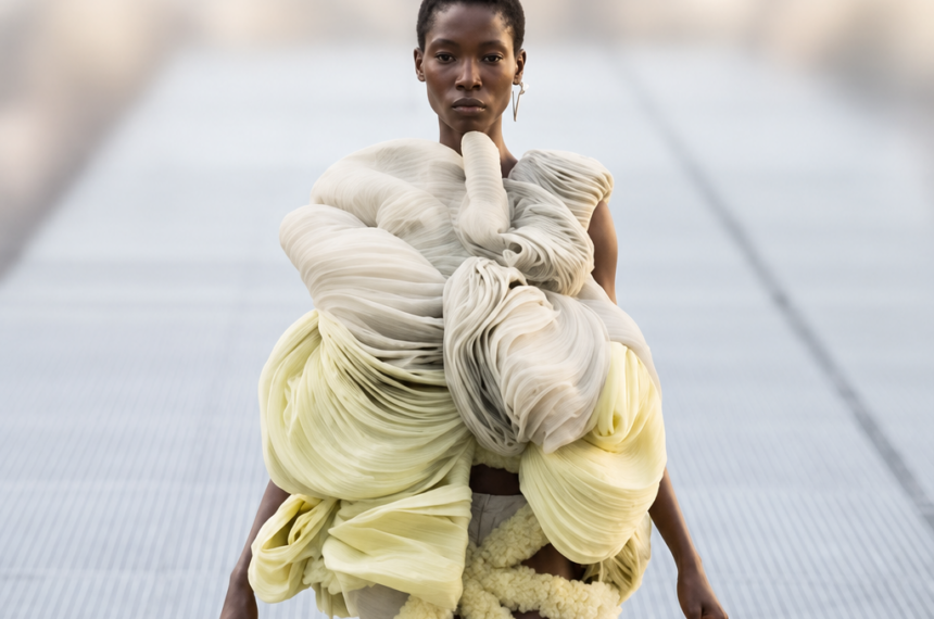 Mannequin du défilé Rick Owens printemps-été 2027 à la Paris Fashion Week, portant une silhouette sculpturale ivoire et jaune pâle.