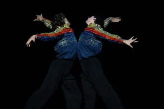 Hugo Marchand et Germain Louvet dans Rings of Saturn, bras courbés et costumes Chanel colorés sur scène.