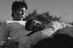 Troye Sivan et un jeune hommes allongé dans les dunes, dans une scène en noir et blanc d’un clip de Troye Sivan.