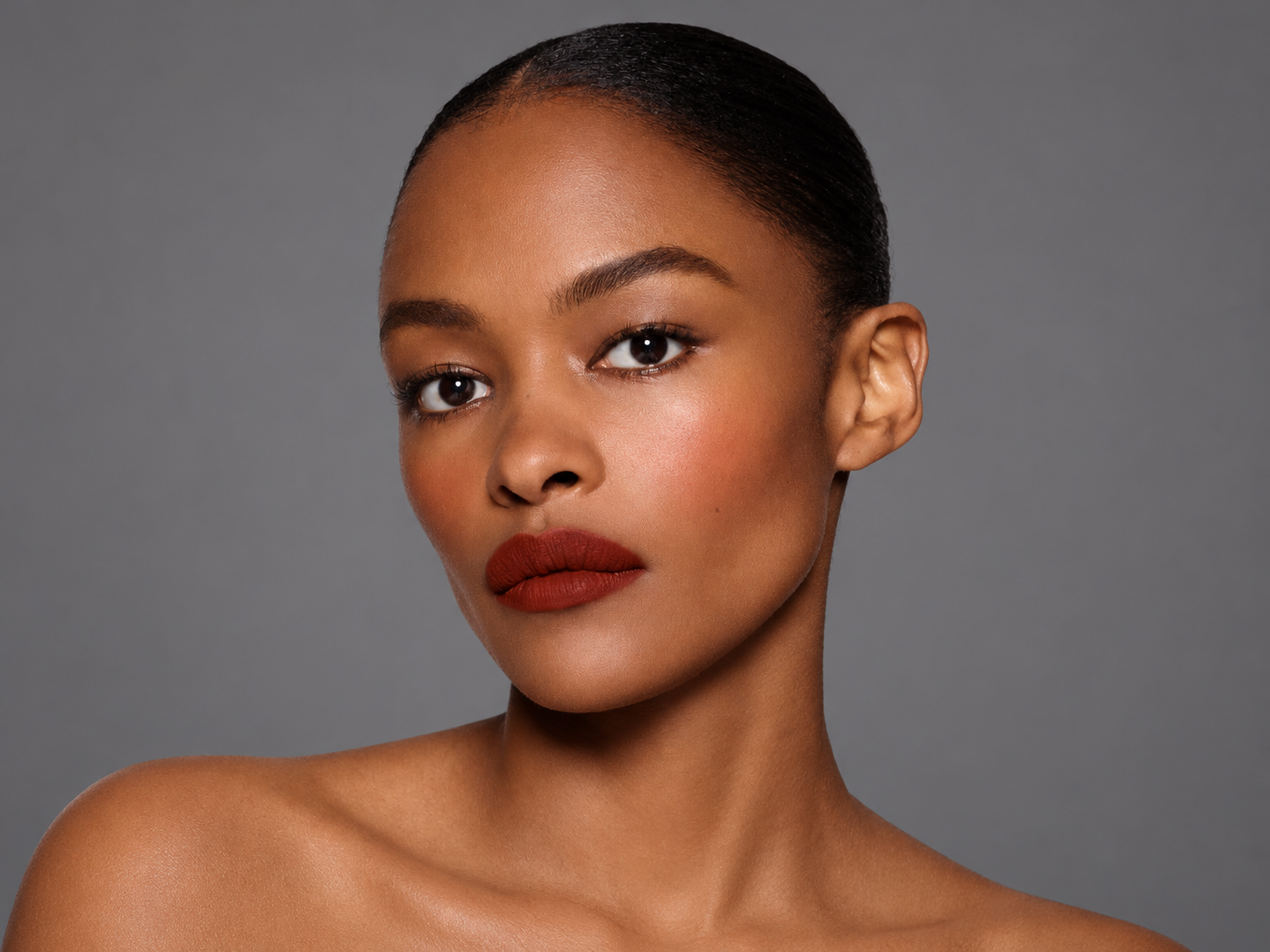 Mannequin portant un rouge à lèvres rouge brique au fini mat, dans un portrait beauté illustrant Rouge Victoria de Victoria Beckham Beauty.