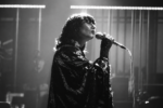 Karen O, chanteuse des Yeah Yeah Yeahs, interprète un morceau au micro dans une scène en noir et blanc du court-métrage Hidden in Pieces.