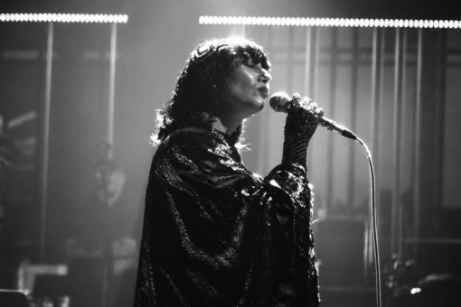 Karen O, chanteuse des Yeah Yeah Yeahs, interprète un morceau au micro dans une scène en noir et blanc du court-métrage Hidden in Pieces.