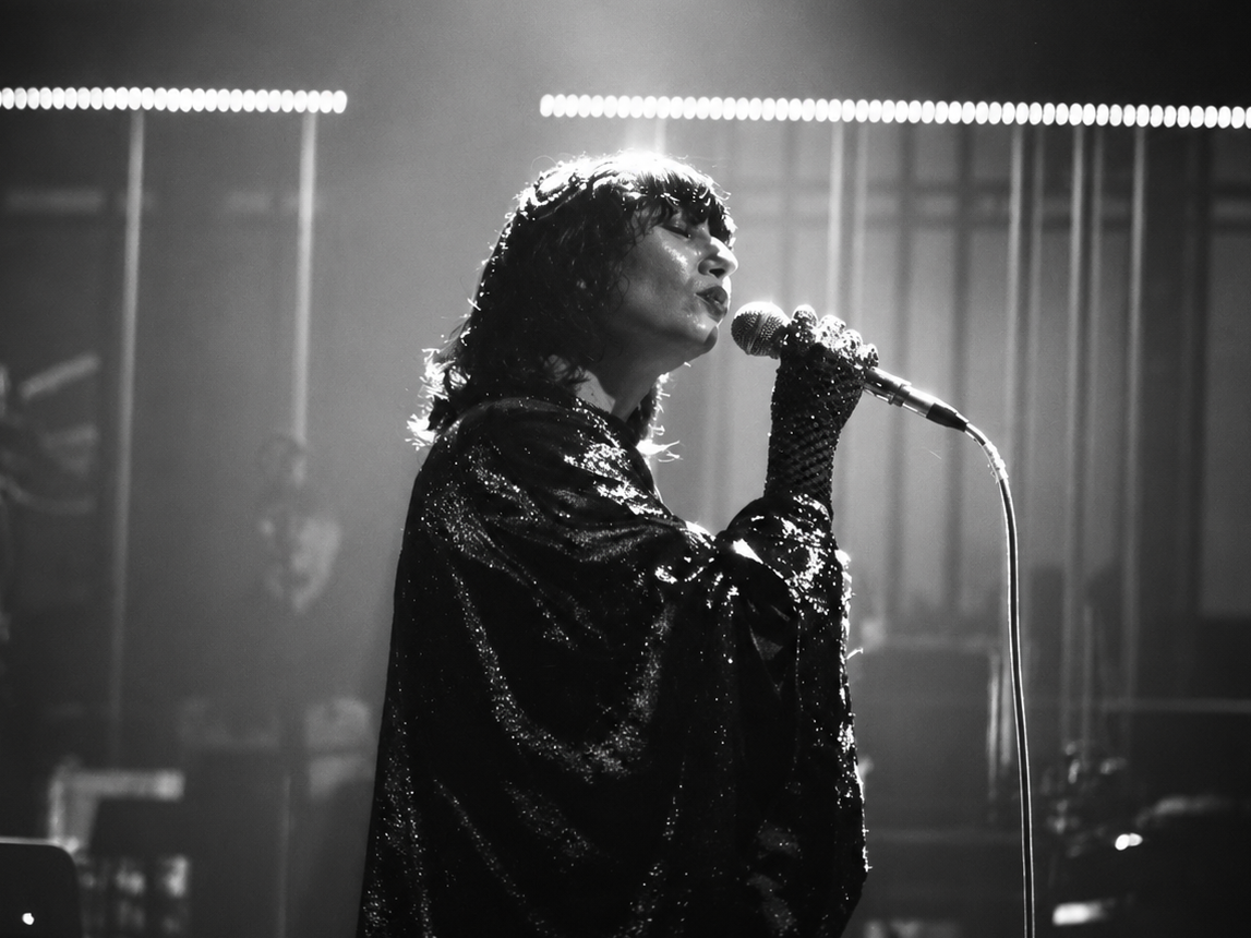 Karen O, chanteuse des Yeah Yeah Yeahs, interprète un morceau au micro dans une scène en noir et blanc du court-métrage Hidden in Pieces.